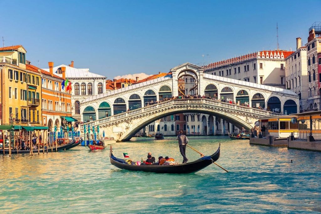 Passeio de gôndola em frente à Ponte Rialto em Veneza.