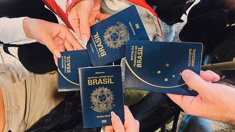 Pessoas segurando seus passaportes brasileiros